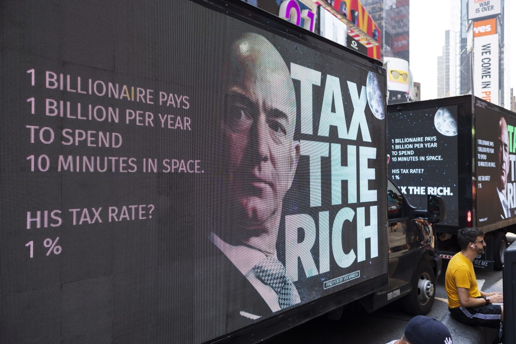 A small group of protesters held a rally in Times Square in New York on July 27, calling for a higher tax rate on the wealthiest Americans, following news of billionaires’ Jeff Bezos and Richard Branson’s privately-funded trips into space. Photo: EPA-EFE