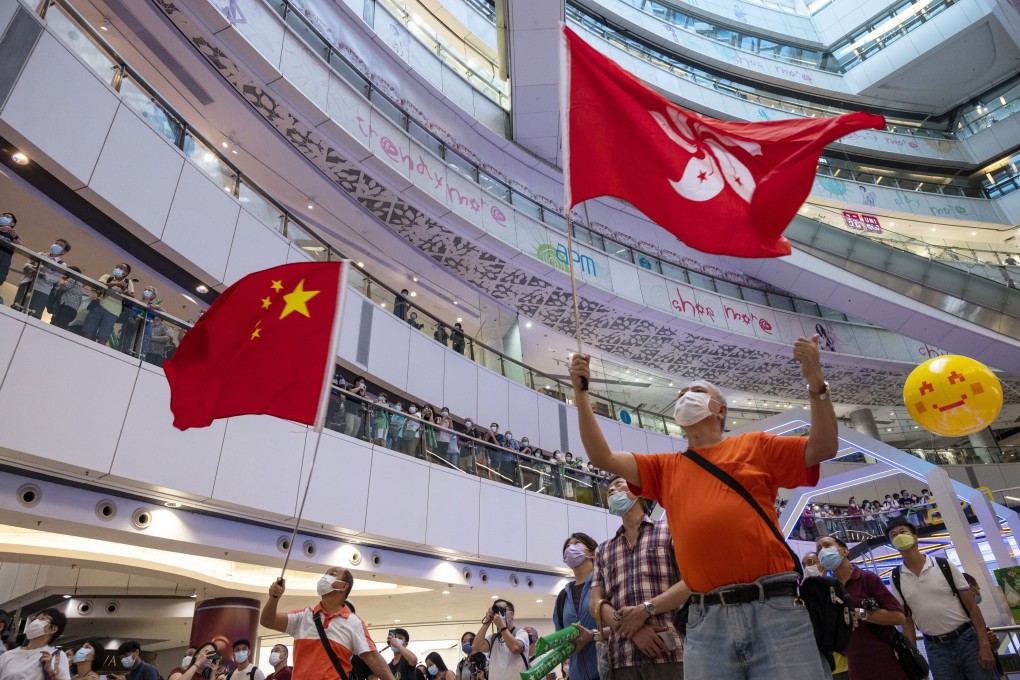 Fans gathered in a shopping mall wave the national and city flags as they watch Hong Kong swimmer Siobhan Haughey take silver in the women’s 100m freestyle at the Tokyo Olympic Games on July 30. Photo: EPA-EFE