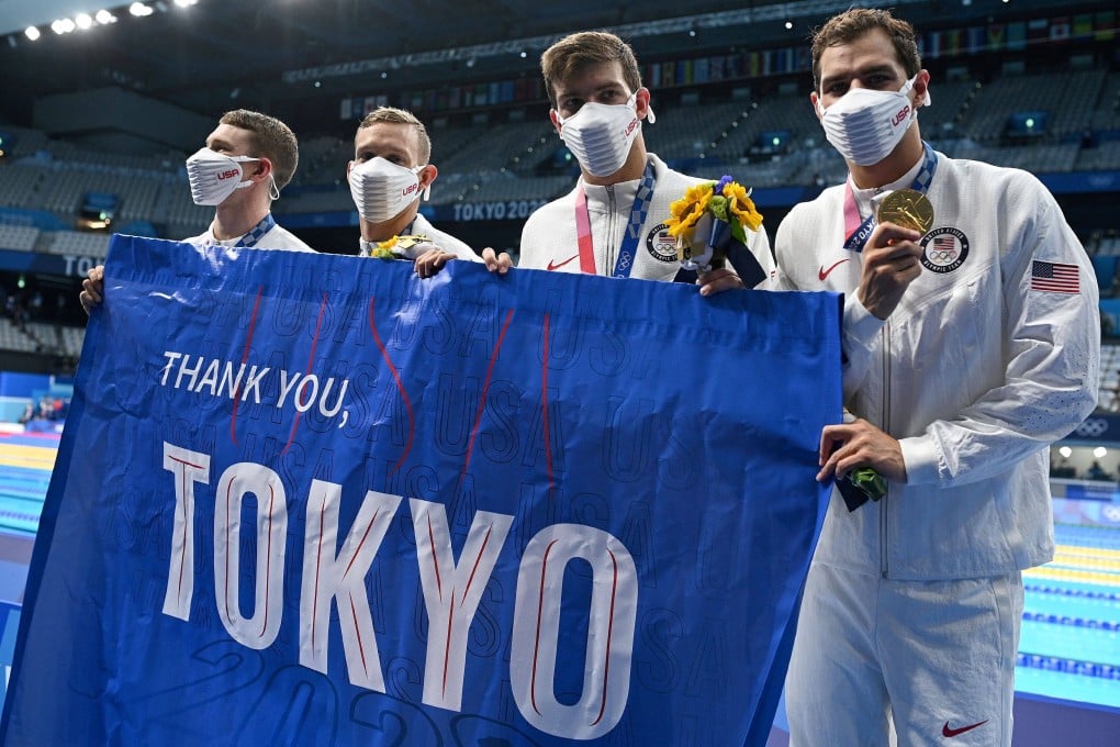 Gold medallist swimmers Ryan Murphy, Caeleb Dressel, Zach Apple, and Michael Andrew, from the US, carry a flag reading “Thank you Tokyo” after winning the final of the men’s 4x100m medley relay at the Tokyo 2020 Olympic Games on August 1. Photo: AFP