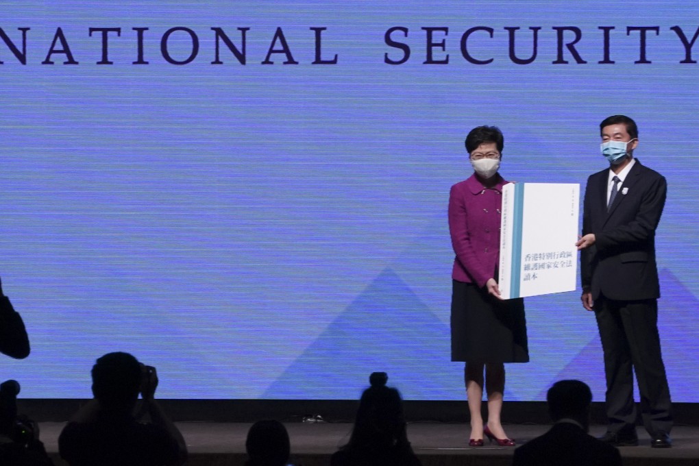 Hong Kong liaison office director Luo Huining presents Chief Executive Carrie Lam Cheng Yuet-ngor with a book on the national security law compiled by mainland academics on April 15. Photo: Felix Wong