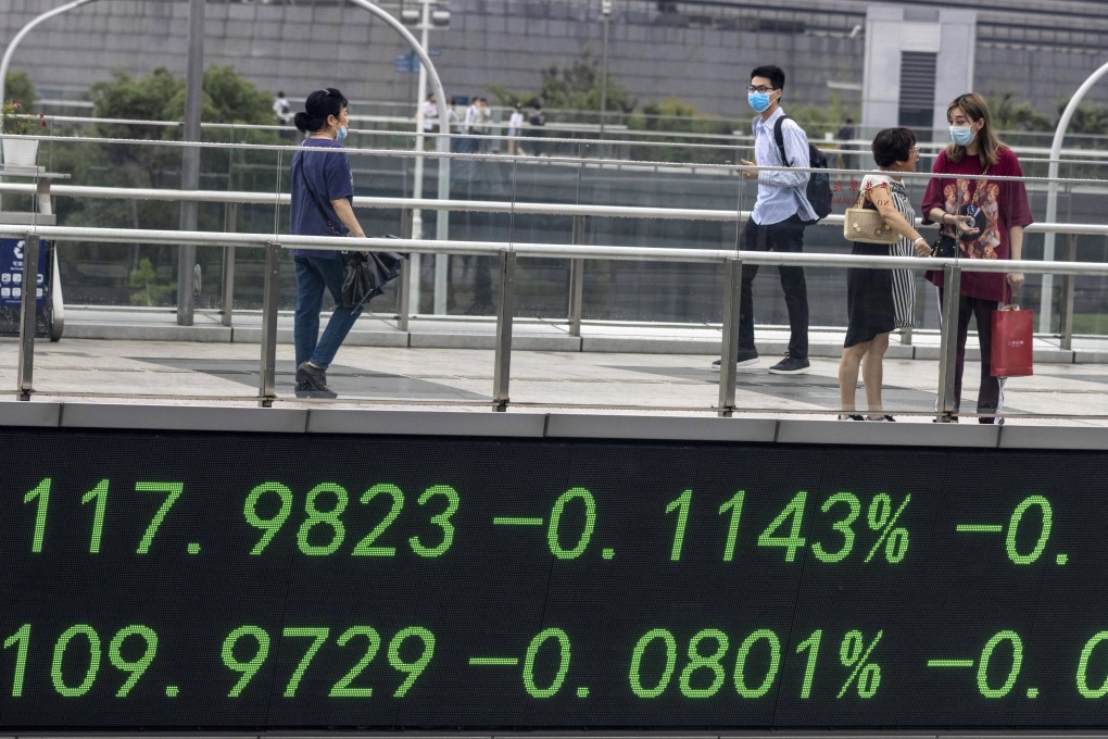 People walk over a pedestrian bridge with a monitor for stock exchange values in Shanghai, China. Photo: EPA