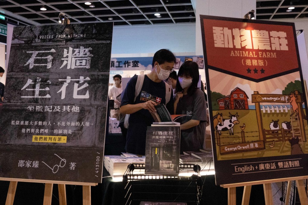 Signs for the Chinese version of George Orwell’s Animal Farm and a book about life in prison are displayed at a booth at the annual Hong Kong Book Fair on July 17. Photo: AFP