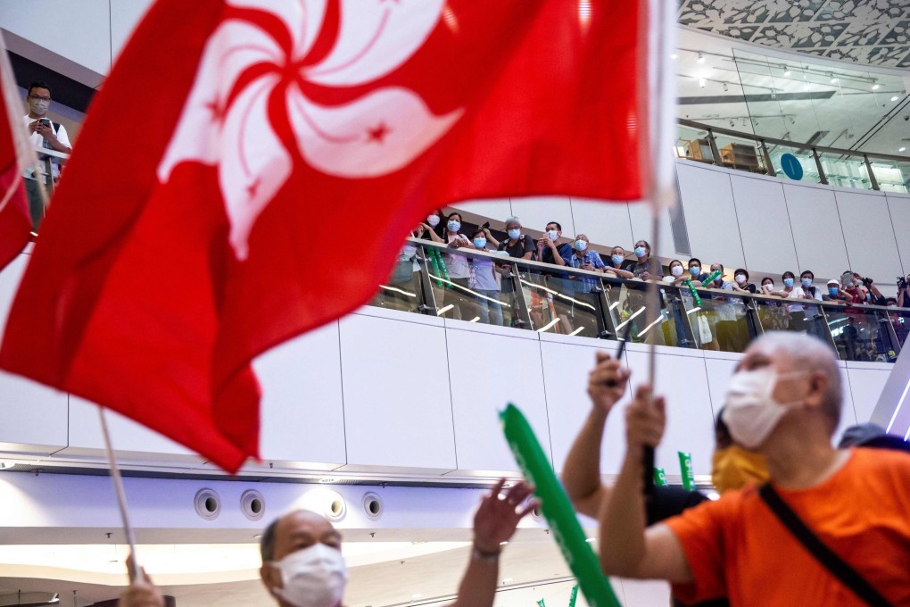 A man waves the Hong Kong flag in a shopping mall in the city while celebrating Siobhan Haughey’s silver medal in the women’s 100m freestyle swimming final, at the Tokyo Olympics on July 30. Photo: AFP