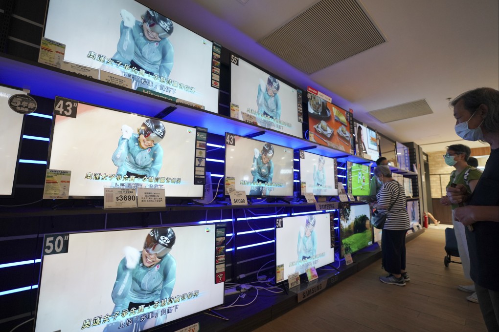 People inside an electrical appliance shop in the Kornhill neighbourhood watch Hong Kong cyclist Sarah Lee Wai-sze win a bronze medal at the Tokyo Olympics on August 8. Photo: Felix Wong