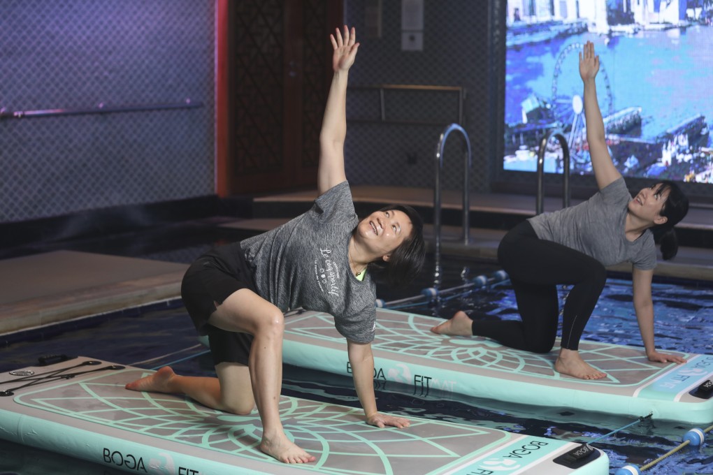 SCMP senior reporter Bernice Chan (left) performs exercises as part of the Mandarin Oriental Hong Kong’s “Aquafit Float” class. Photo: Xiaomei Chen