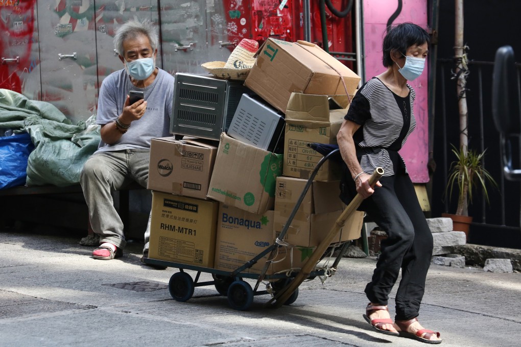 A woman pulls a trolley of cardboard boxes and old electronics down Elgin Street in Central in August 2020. Photo: Jonathan Wong