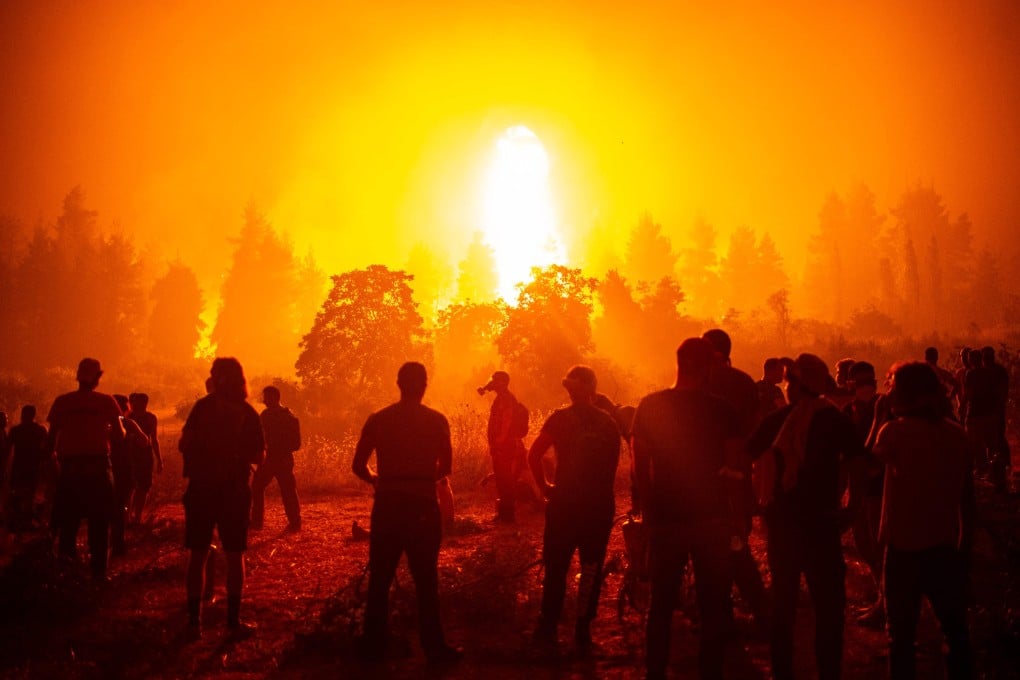 Volunteers support firefighters during a wildfire next to the village of Kamatriades in Greece. Photo: AFP