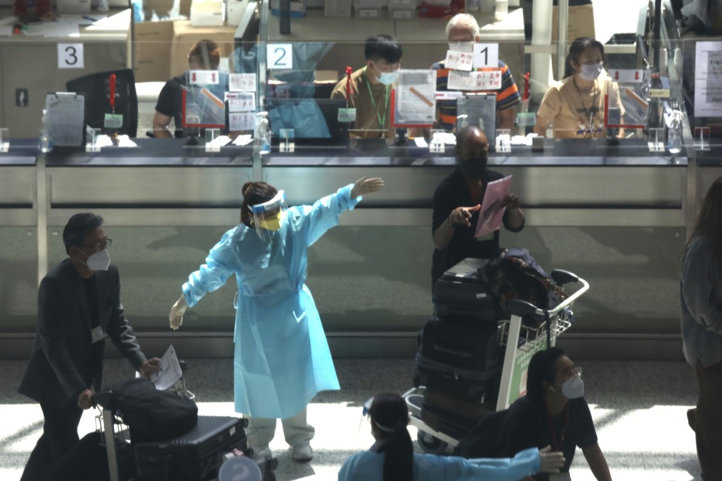 An airport worker directs arrivals at Hong Kong International Airport on August 19. Hong Kong has ended a rule that allowed travellers from many parts of the world with positive antibody tests to shorten their quarantine periods. Photo: Xiaomei Chen