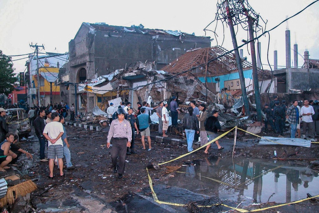 Police and onlookers at the site of a bomb blast in the tourist area of Kuta where over 200 people were killed. Photo: AFP