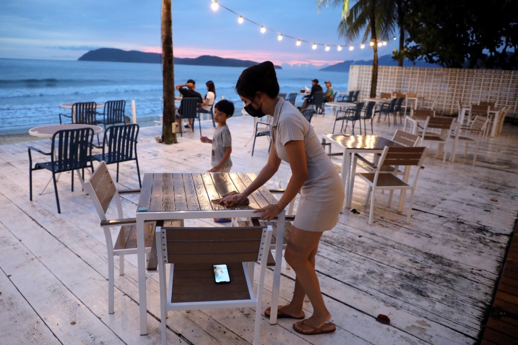 Esther Lee, owner of the Hidden Langkawi restaurant, cleans a table at her restaurant as Langkawi gets ready to open to domestic tourists from September 16. Photo: Reuters