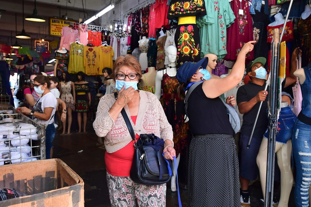 A woman adjusts her facemask while shopping in a clothing store on July 19 in Los Angeles, California. US economic growth “downshifted slightly” in July and August amid shortages of workers and materials, as well as concerns about the rise of the Delta variant of Covid-19, the Federal Reserve said on September 8. Photo: AFP