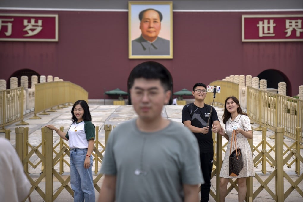 Visitors pose for photos near the large portrait of Chinese leader Mao Zedong on Tiananmen Gate next to Tiananmen Square in Beijing on September 18. Photo: AP