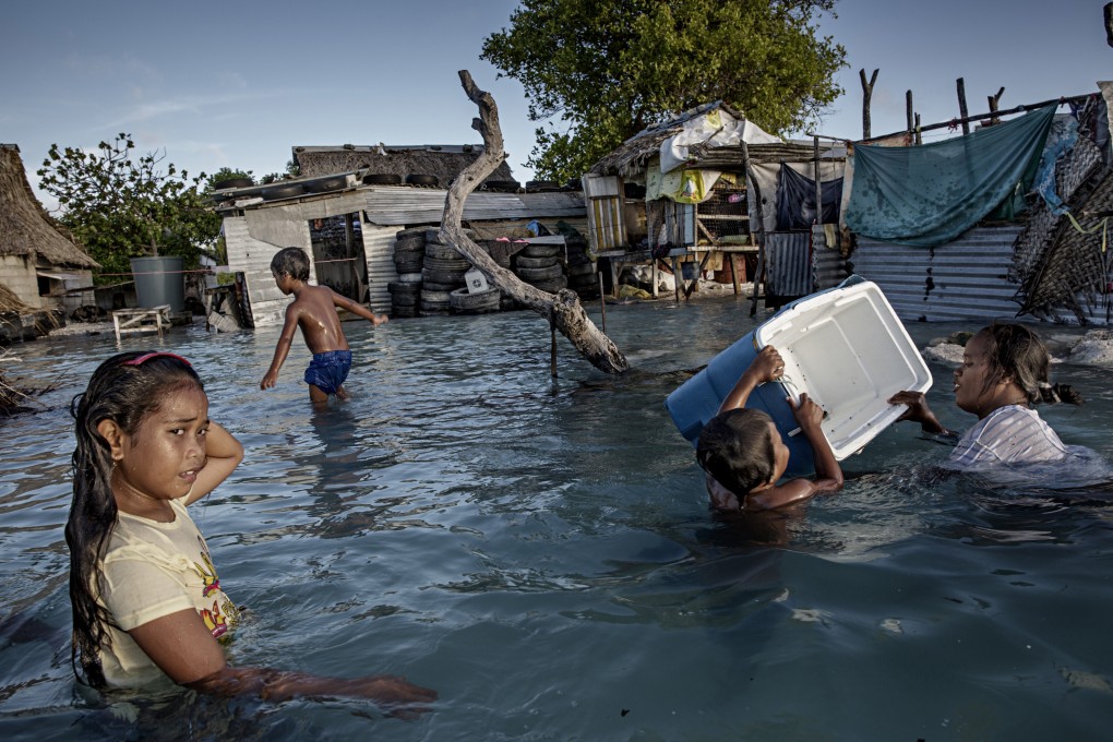 Flooding from the sea in a village in Kiribati, a small island developed state, in September 2015. While the people of Kiribati account for little to nothing in terms of greenhouse gas emissions, they are forced to face the direct consequences of global warming. Photo: LightRocket via Getty Images