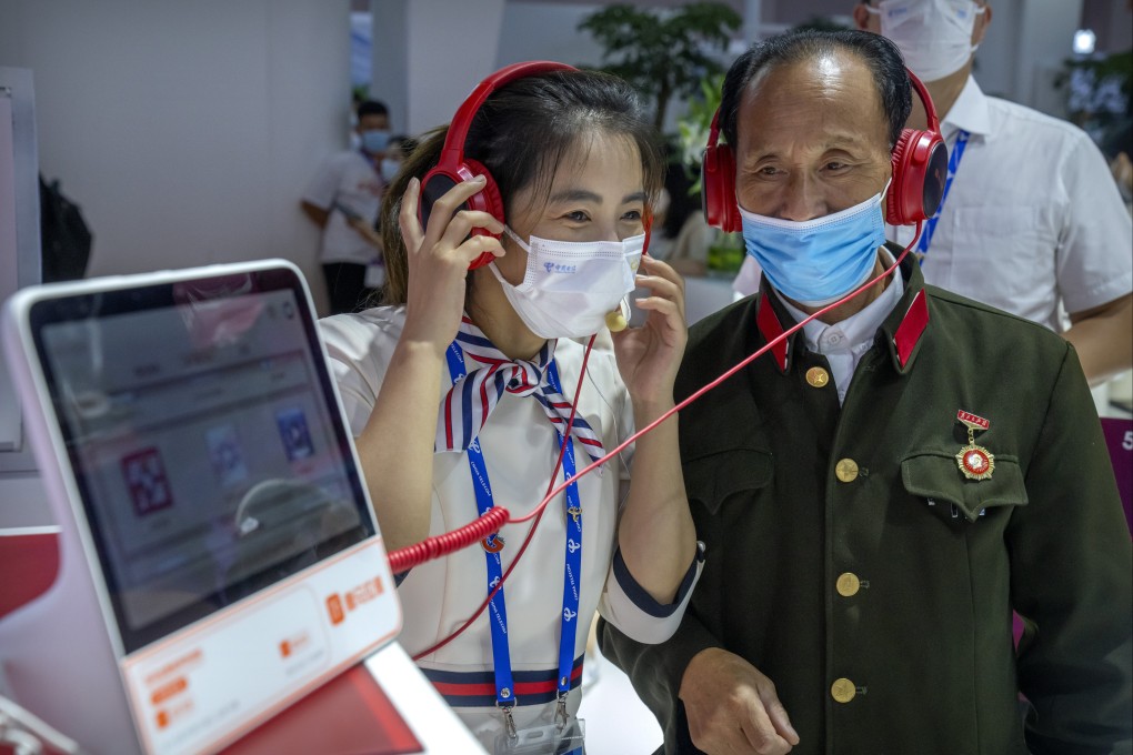 An attendant demonstrates a display for an elderly Chinese military veteran at a booth for Chinese telecom provider China Telecom at the PT Expo in Beijing on September 28. While older people are among the least digitally connected population groups, they are among the most vulnerable to cyberthreats. Photo: AP