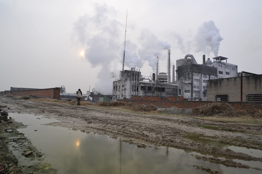 A local resident walks past at a chemical factory in Xiangfan, Hubei province, China. The country is the fastest-growing and largest chemical producer in the world, science writer Julian Cribb points out in his new book Earth Detox. Photo Jie Zhao/Corbis via Getty Images