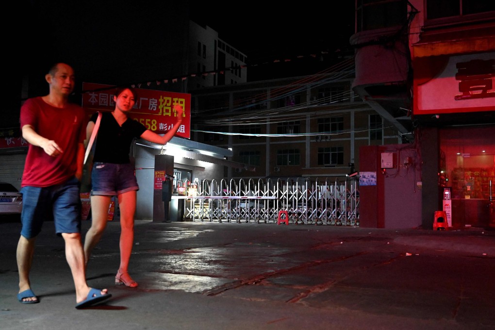 People walk past an industrial park in Houjie, in Dongguan, Guangdong province, on September 30, amid power shortages and restrictions across China. Photo: AFP