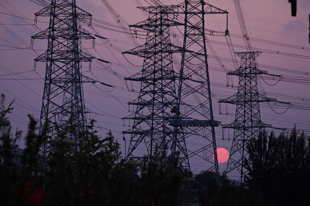 The sun sets behind electricity pylons in Beijing on September 28. Coronavirus outbreaks, a cooling housing market and spreading power shortages have been weighing on the Chinese economy. Photo: AFP