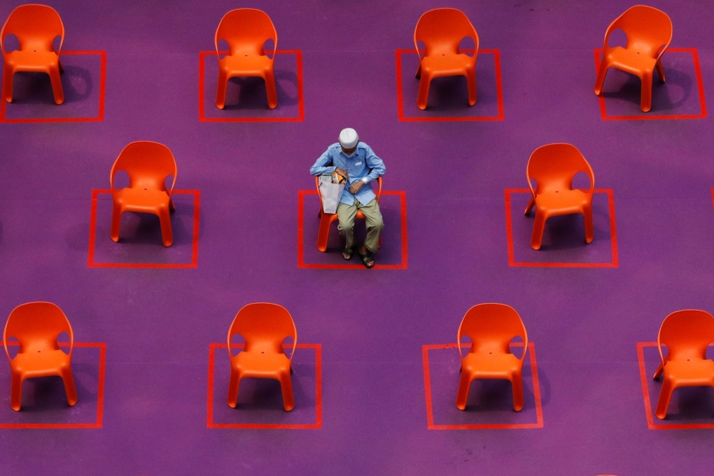 A man sits among empty seats at a free movie screening in Singapore, on September 29, as restrictions on social gathering are tightened due to the surge of Covid-19 cases. Photo: Reuters