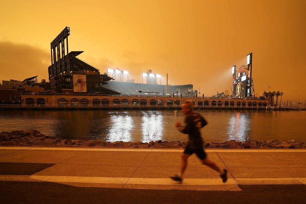A jogger runs along McCovey Cove outside Oracle Park in San Francisco, under skies reddened from wildfire smoke, on September 9, 2020. Photo: AP