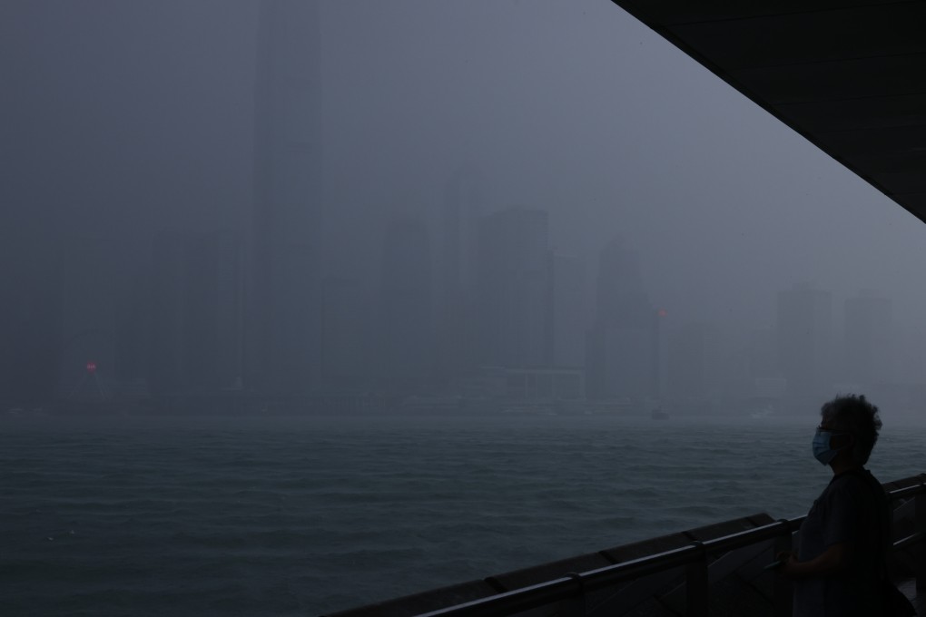 A woman looks out across Victoria Harbour as the Hong Kong Observatory issues the first typhoon warning No 1 signal in 2021 on June 11. In October, Hong Kong issued two No 8 storm warning signals in four days. Photo: Dickson Lee
