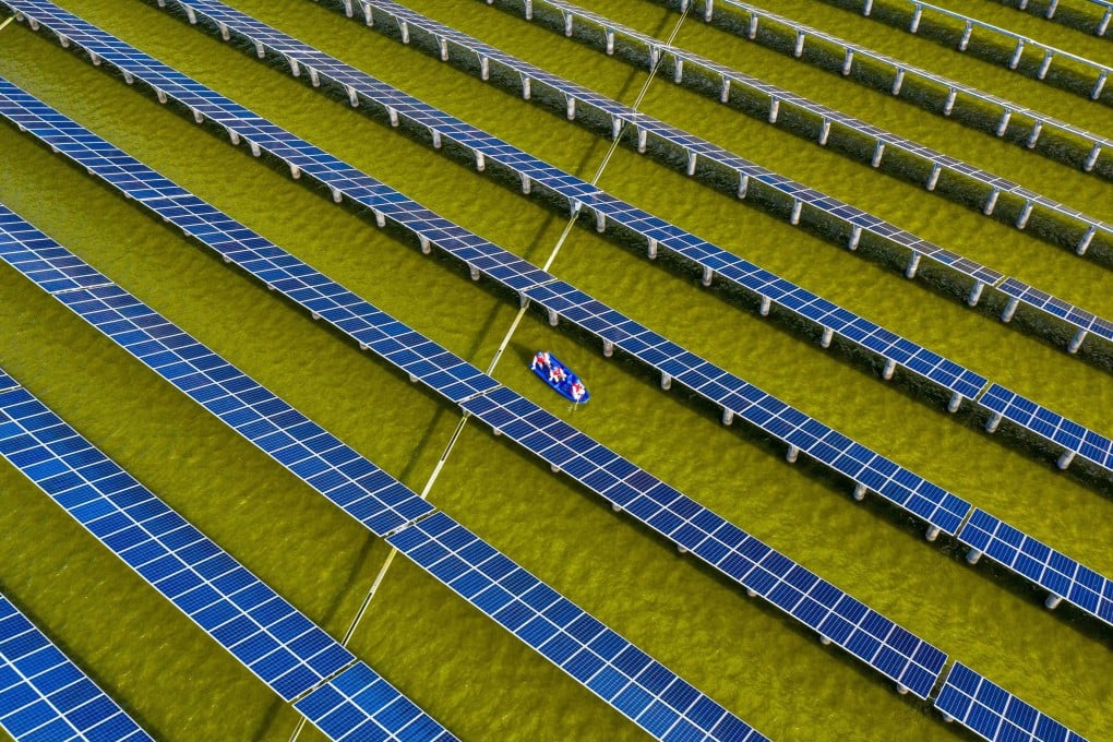 Workers in a boat check solar panels at a photovoltaic power station built on a fishpond in Haian, in China’s eastern Jiangsu province, on July 19. Photo: AFP