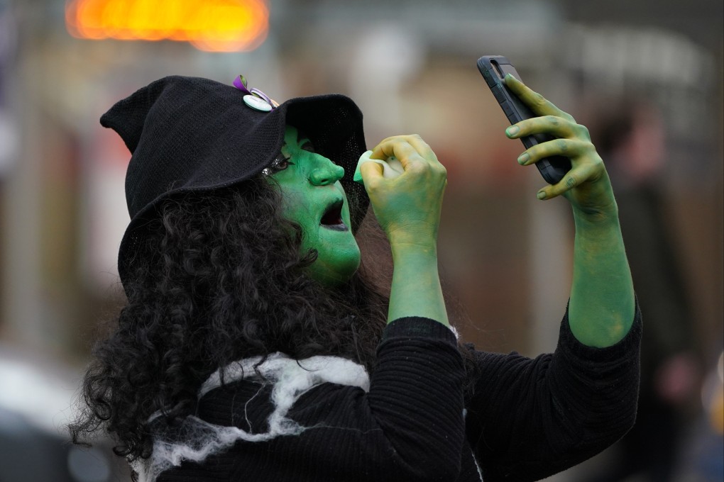 A woman from the campaign group Women Won’t Wheesht dressed as a witch touches up her make-up in George Square, Glasgow, at the start of the COP26 climate summit on October 31. Photo: dpa