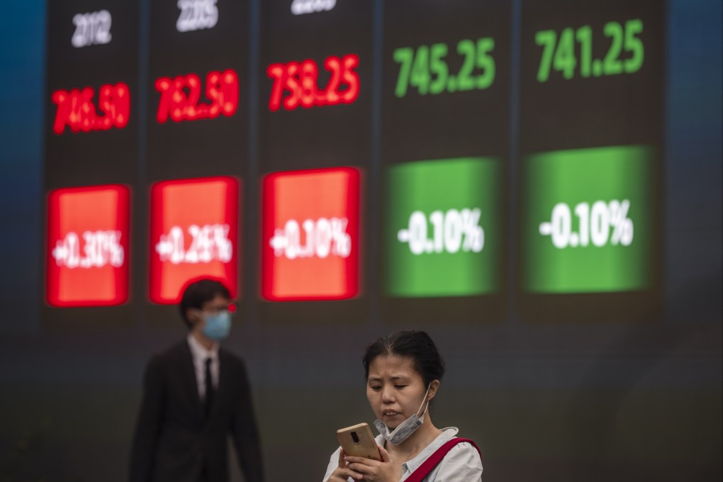 A woman stands in front of a screen showing stock exchange and economic data in Shanghai, on October 7. Photo: EPA-EFE