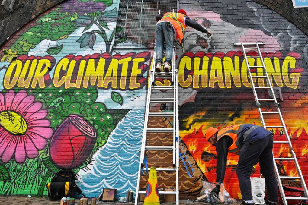 Artists paint a climate change mural on a wall in Glasgow, Scotland. Traditional marketing needs to give way to advertising that promotes the message that making greener choices is possible, insiders say. Photo: Getty Images