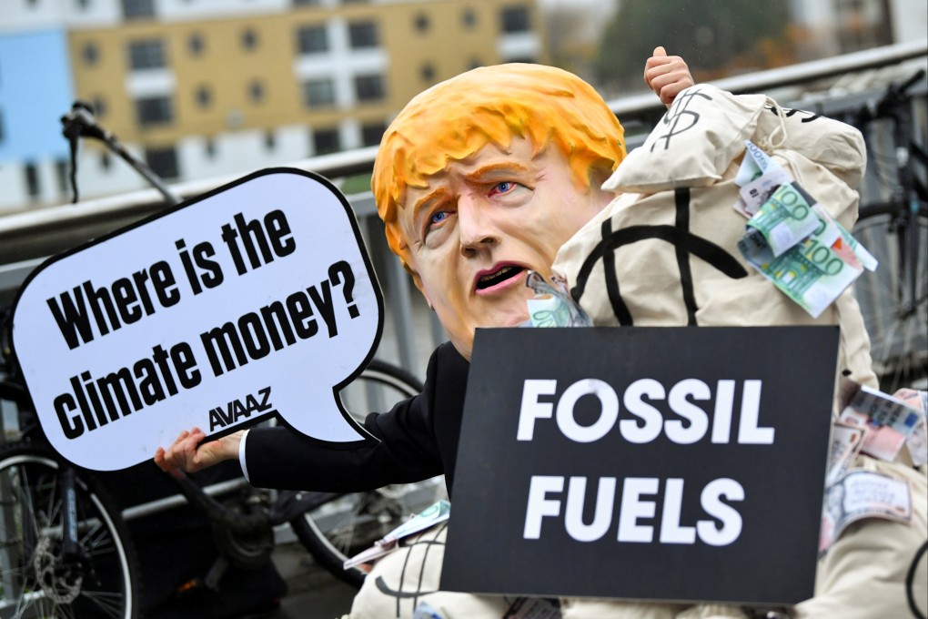 A person wearing a mask depicting Britain’s Prime Minister Boris Johnson protests during COP26 in Glasgow, Scotland, on November 12. An effective carbon trading system is a necessary tool in the transition to a net-zero economy. Photo: Reuters