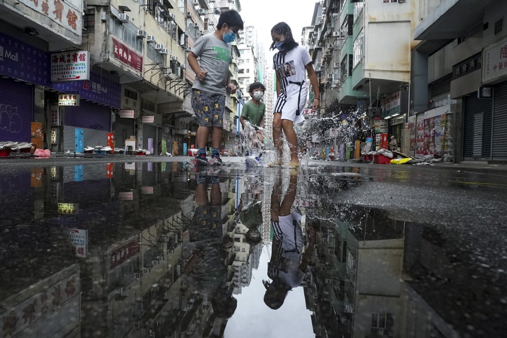Children splash in puddles on Tung Choi Street on October 13. In rich and peaceful Hong Kong, every child should be happily going to school, getting a good education and playing with their peers. Photo: Felix Wong