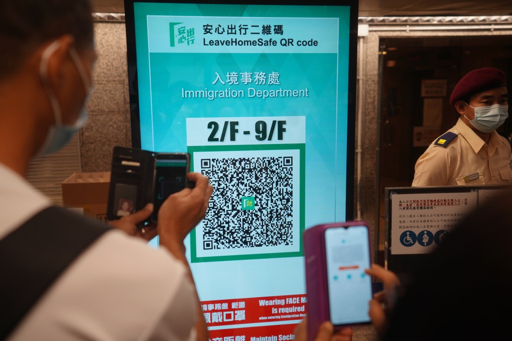 People scan the QR code for the government’s “Leave Home Safe” risk-exposure app to enter Immigration Tower in Wan Chai. Photo: Winson Wong
