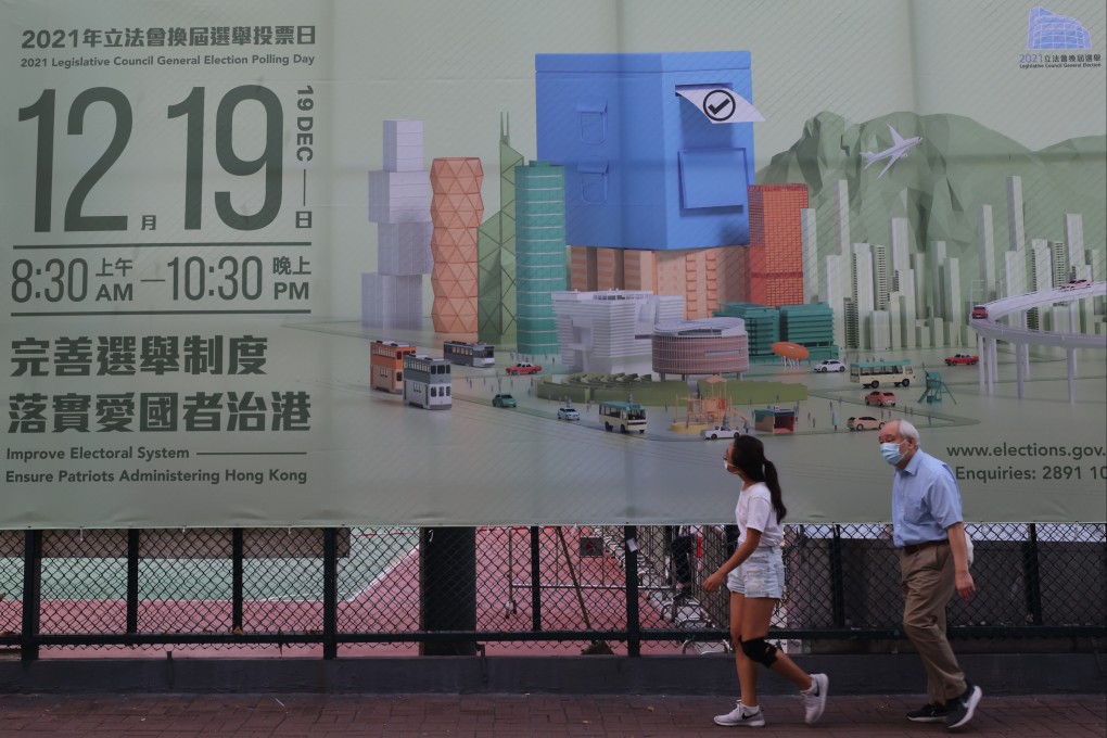 People walk past a banner in Mong Kok on November 12 promoting the Legco election, which will be held on December 19. Photo: Dickson Lee