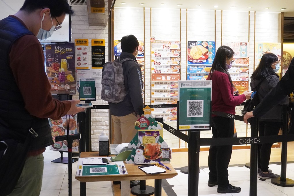 Hongkongers use the ‘Leave Home Safe’ app to enter a restaurant in Admiralty on Wednesday. Photo: Sam Tsang