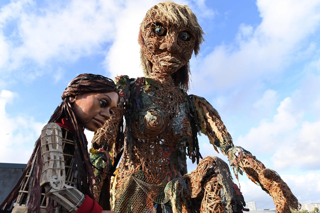 Storm, (R), a 10-metre tall “goddess of the sea” puppet who carries a message of the oceans in crisis, meets Little Amal, a 3.5-metre tall Syrian refugee puppet in Glasgow in November 2021 during the Cop26 UN Climate Change Conference. Photo: AFP