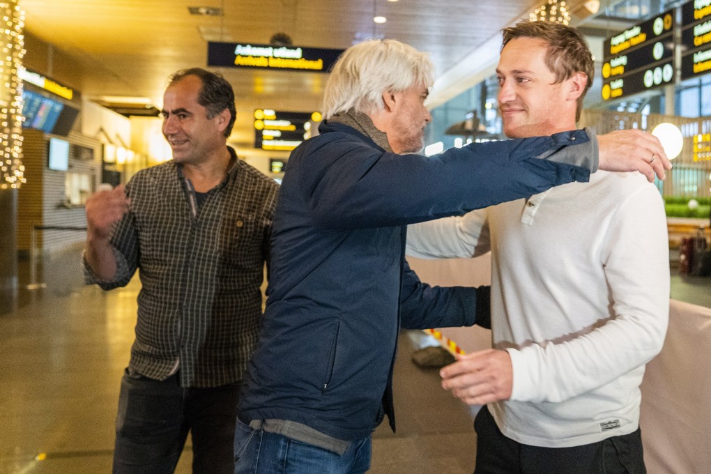 NRK journalists Halvor Ekeland (right) and Lokman Ghorbani (left) are received by head of NRK sports Egil Sundvor (C) after returning from Qatar. Photo: EPA