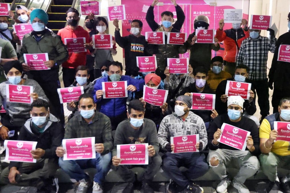 Foodpanda workers hold up protest slogans. Photo: May Tae