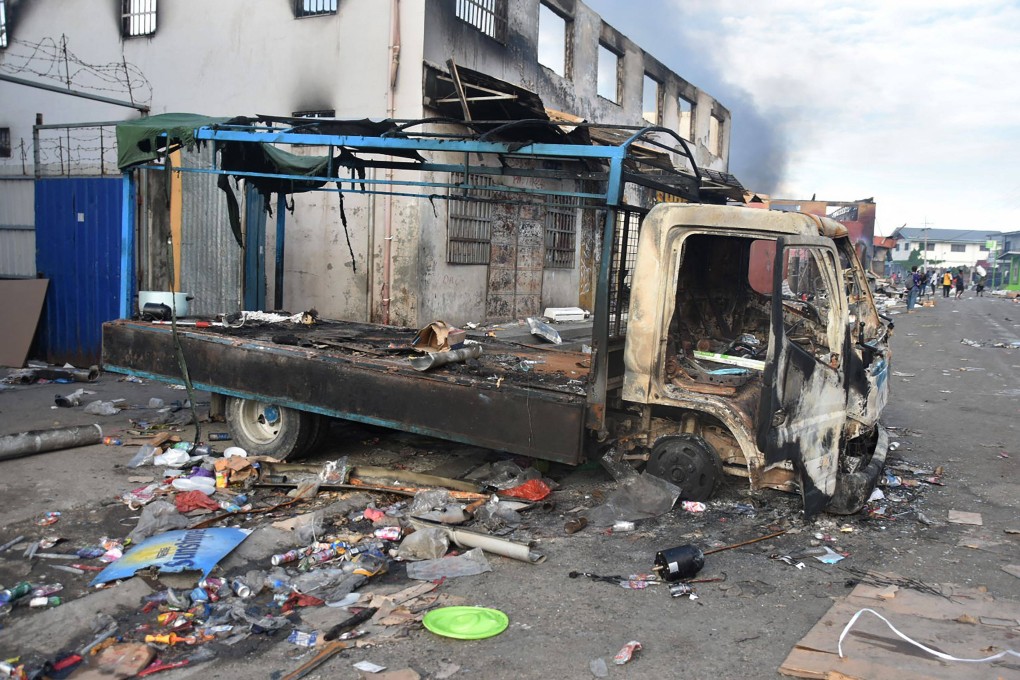 A burnt out truck sits in the Chinatown district of Honiara on the Solomon Islands on November 26, 2021, after a third day of violence. Photo: AFP