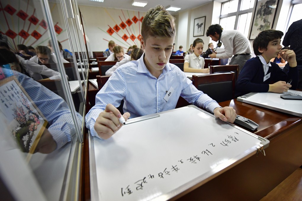 Participants write Chinese characters on white boards at the final of a Chinese language dictation contest at a Vladivostok Confucious Institute in Russia. Photo: Getty Images