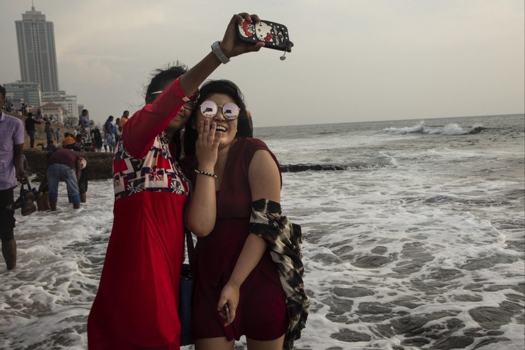 A Chinese tourist takes a selfie with a Sri Lankan friend in Colombo, Sri Lanka. The days of cheap and cheerful travel may have come to an end. Photo: Getty Images