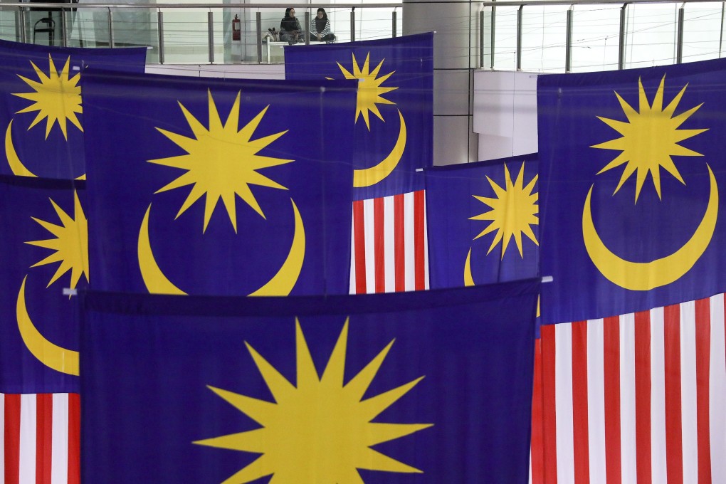 Women have a chat near giant Malaysian national flags inside a shopping mall in Bangi, outside Kuala Lumpur. Photo: EPA-EFE