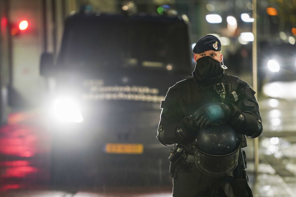 Members of the Royal Netherlands Marechaussee are deployed as protesters gather outside the Ministry of Justice and Security in the Hague on Friday while Dutch Prime Minister Mark Rutte holds a press conference on new coronavirus restrictions. Photo: EPA-EFE
