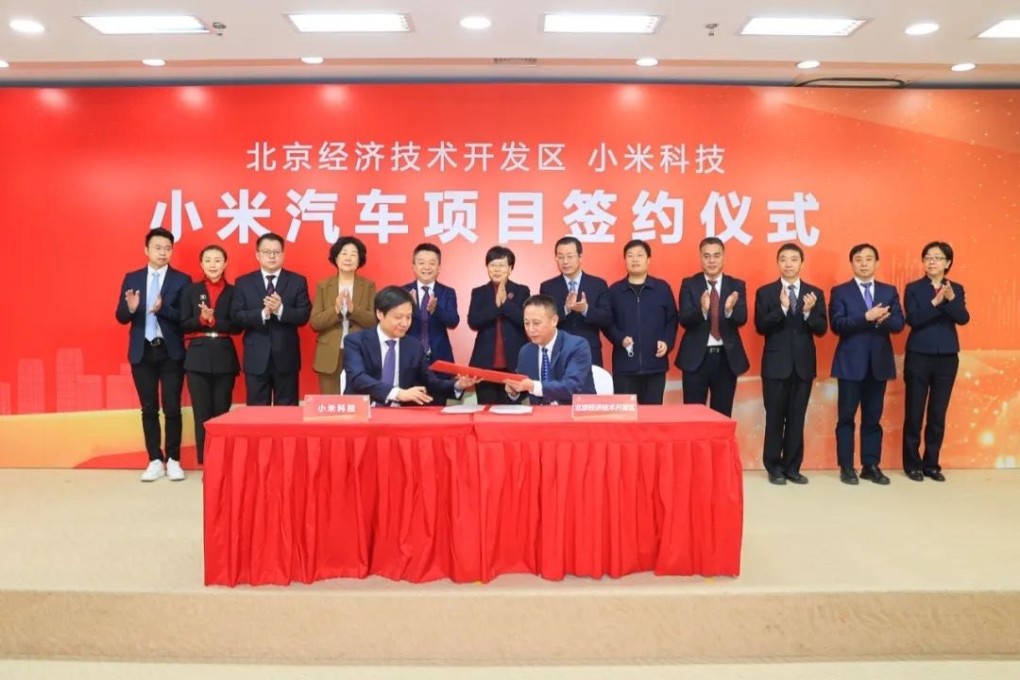 Xiaomi founder and CEO Lei Jun (left in front) signs a deal with local government officials to set up an electric vehicle factory at the Yizhuang economic development zone. Photo: Handout