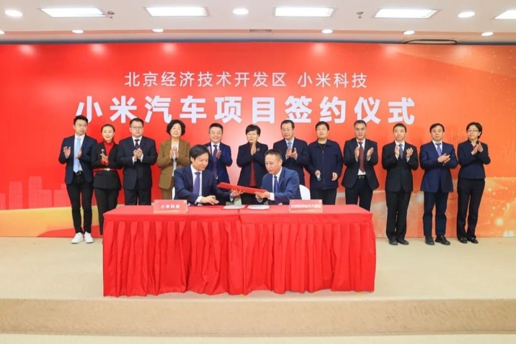 Xiaomi founder and CEO Lei Jun (left in front) signs a deal with local government officials to set up an electric vehicle factory at the Yizhuang economic development zone. Photo: Handout