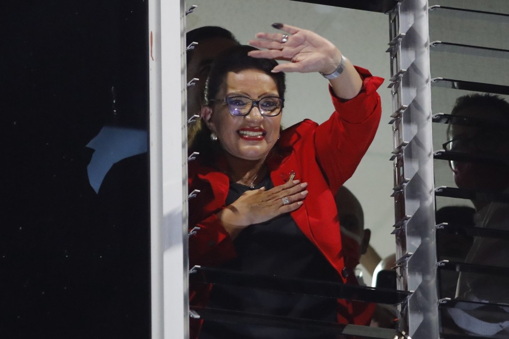 Honduras presidential candidate Xiomara Castro greets supporters from a window in Tegucigaloa after hearing the partial results of the elections. Photo: EPA