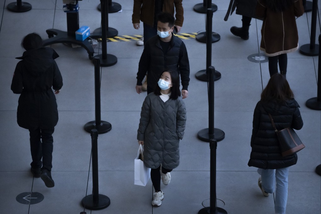 People wearing face masks while waiting to enter a store at an outdoor shopping centre in Beijing. Photo: AP
