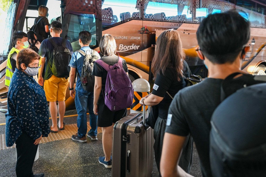 People board a bus in Singapore as a land border with Malaysia reopens on November 29, 2021. Photo: AFP