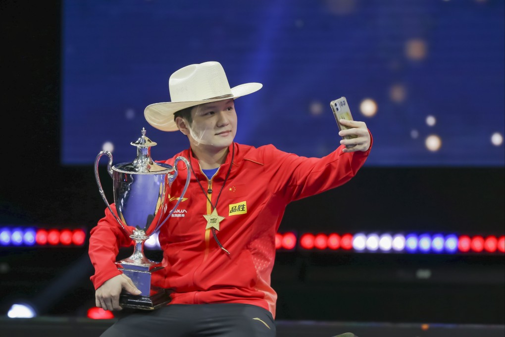 Fan Zhendong takes a selfie with the St. Bride Vase after winning the men’s singles title at the 2021 World Table Tennis Championships. Photo: EPA-EFE