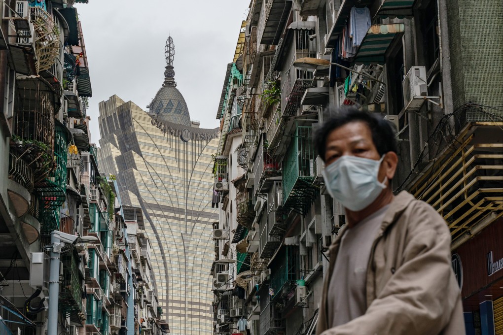 A man wearing protective mask walks across a street in front of the Grand Lisboa Hotel in Macau. Photo: Getty Images
