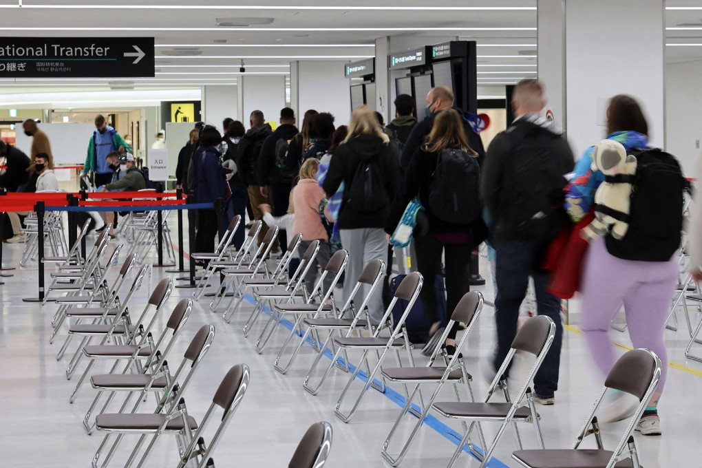 People wait to be transported to a quarantine facility after arriving at the airport in Narita, Japan. Photo: Jiji Press/AFP