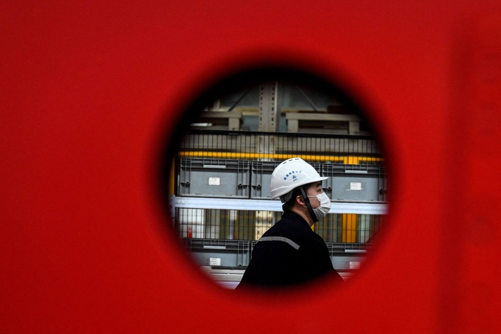 An employee works on a machine production line at a factory in Beijing on October 15. While industrial output in China has been hit by power shortages, this shock is likely to be short-lived, unlike the more long-term impact of Covid-19. Photo: AFP